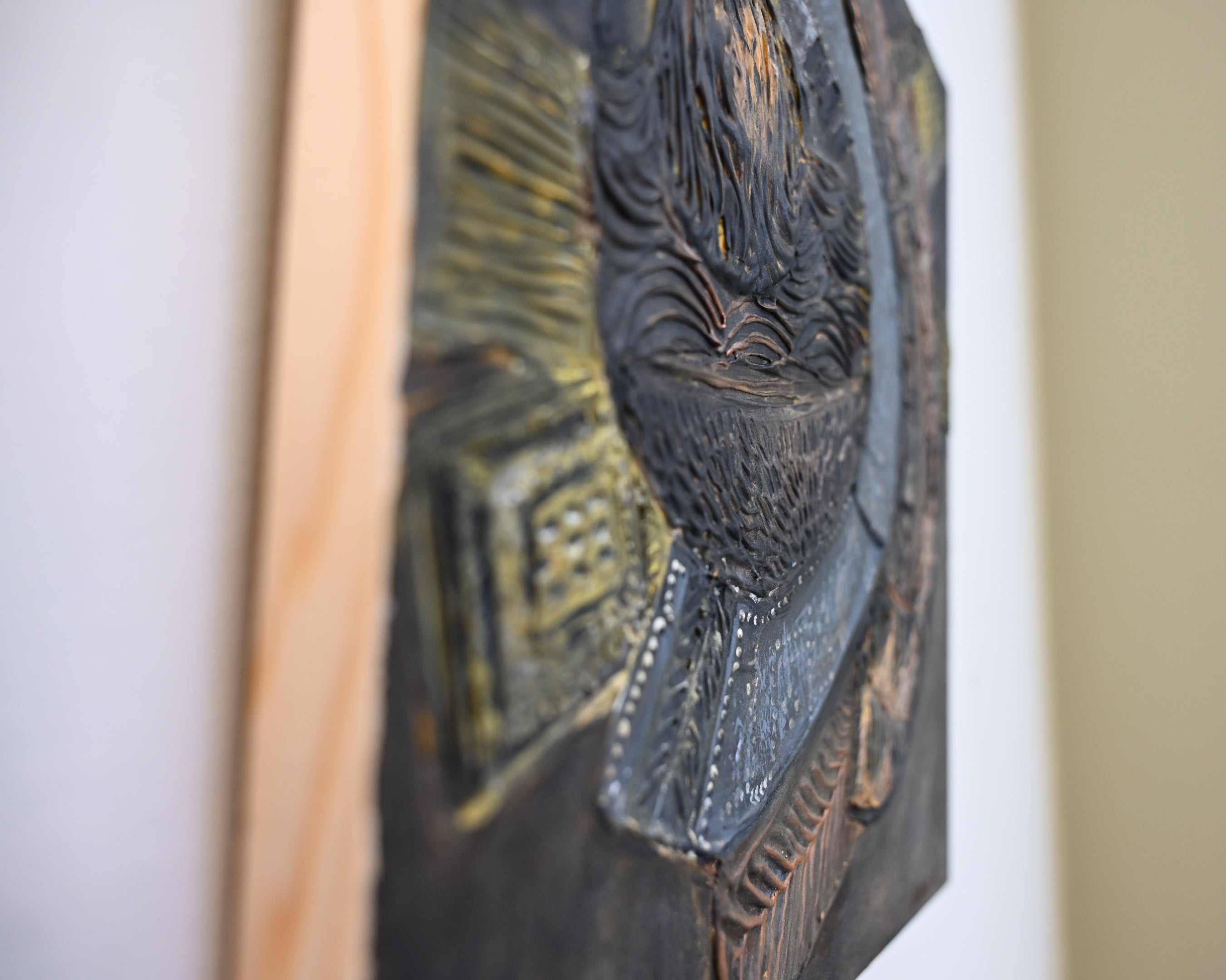 Textured abstract relief artwork inspired by carved artifacts and historical decorative forms.
