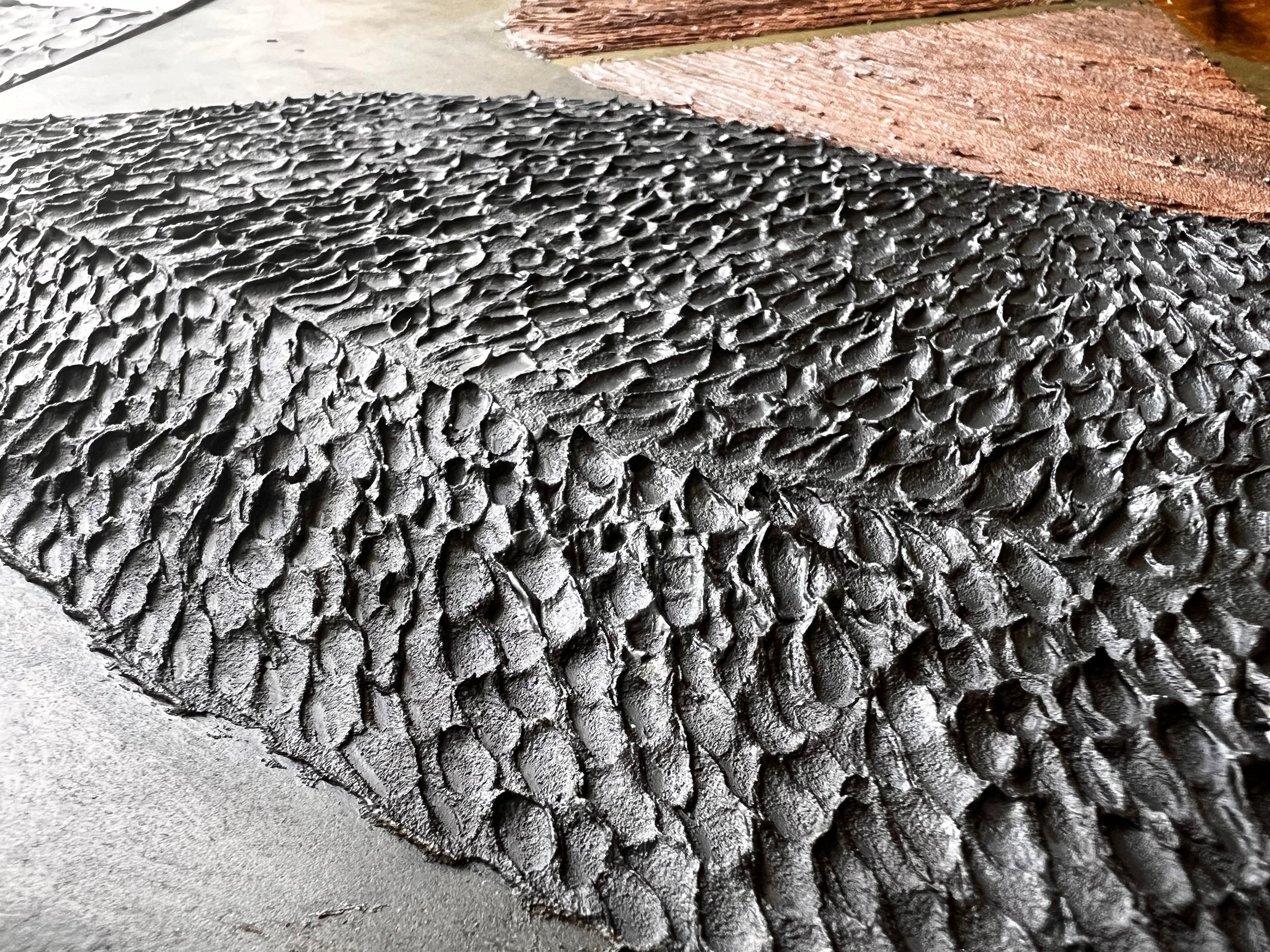Textured contemporary relief artwork inspired by traditional wood carving techniques and organic material forms.